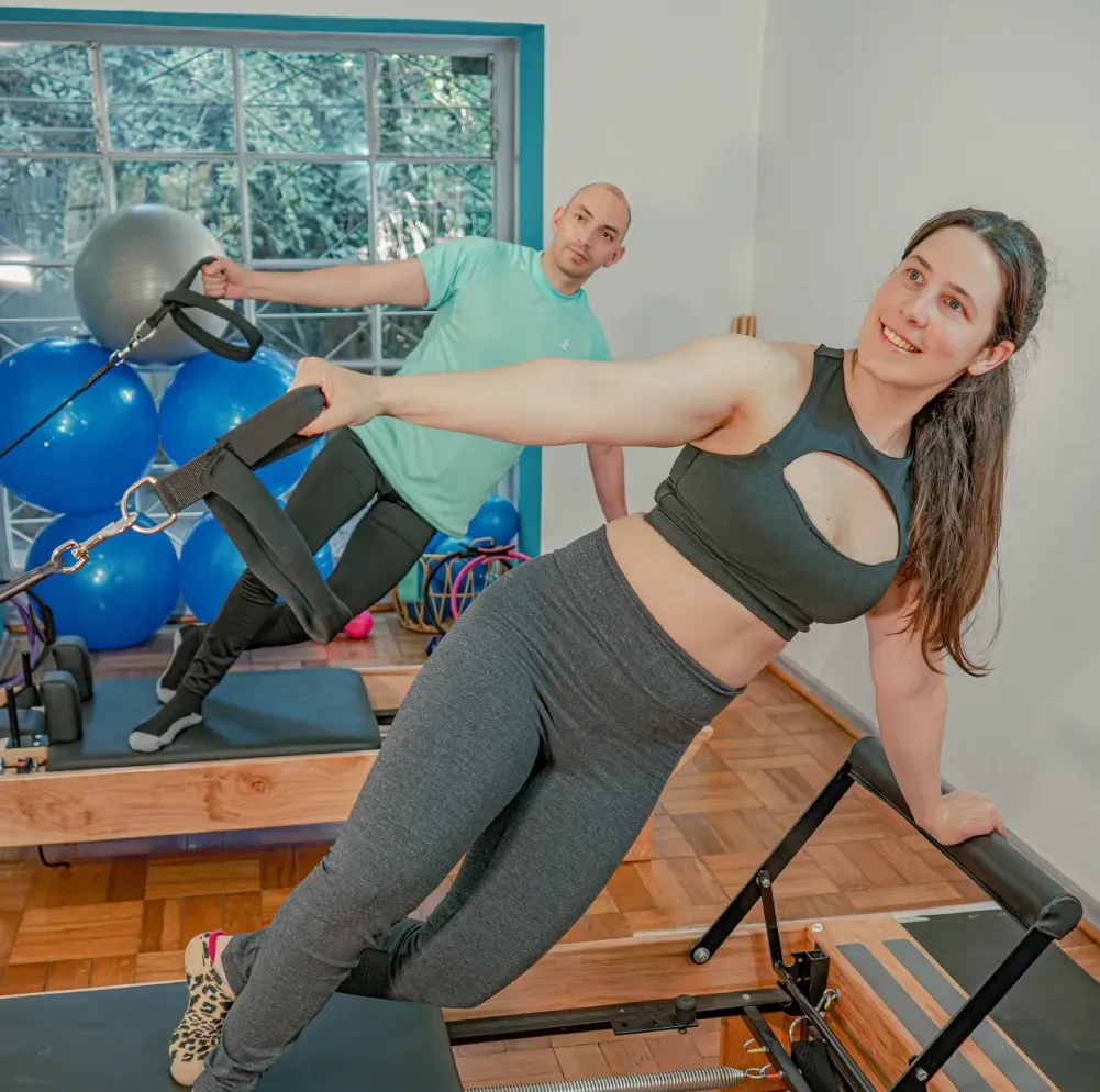 Alumna trabajando fuerza en una cama de Pilates Reformer